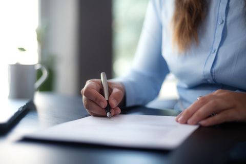 Eine Frau unterschreibt ein Dokument