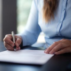 Eine Frau unterschreibt ein Dokument Eine Frau unterschreibt ein Dokument