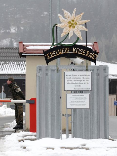 Ein Militärfahrzeug passiert einen Checkpunkt. Zwei Soldaten sprechen miteinander