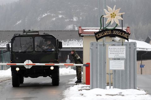 Ein Militärfahrzeug passiert einen Checkpunkt. Zwei Soldaten sprechen miteinander Ein Militärfahrzeug passiert einen Checkpunkt. Zwei Soldaten sprechen miteinander