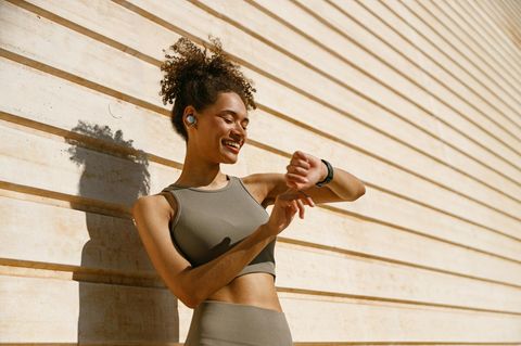 Frau schaut auf ihre Fitness-Smartwatch und misst Schritte Frau schaut auf ihre Fitness-Smartwatch und misst Schritte