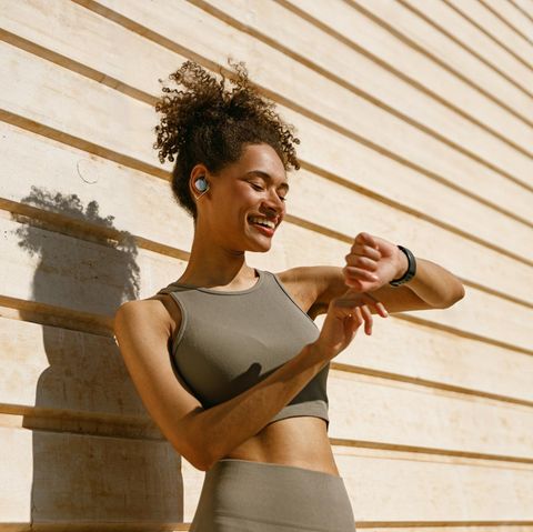 Frau schaut auf ihre Fitness-Smartwatch und misst Schritte Frau schaut auf ihre Fitness-Smartwatch und misst Schritte