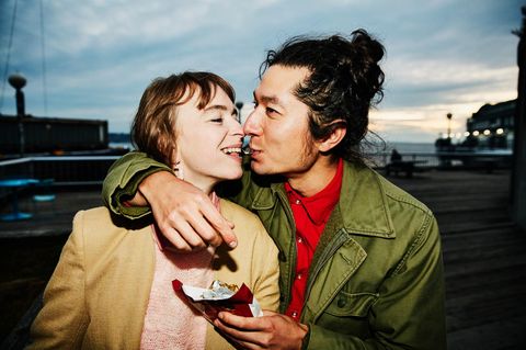 Gefühle: Ein Paar teilt sich Schokolade. Er umarmt sie dabei. Gefühle: Ein Paar teilt sich Schokolade. Er umarmt sie dabei.