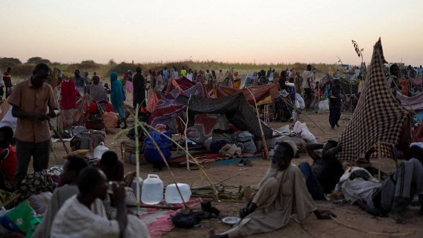 Menschen sitzen in einem Lager für vertriebene Familien, die aus Al-Fashir, Sudan geflohen sind Menschen sitzen in einem Lager für vertriebene Familien, die aus Al-Fashir, Sudan geflohen sind