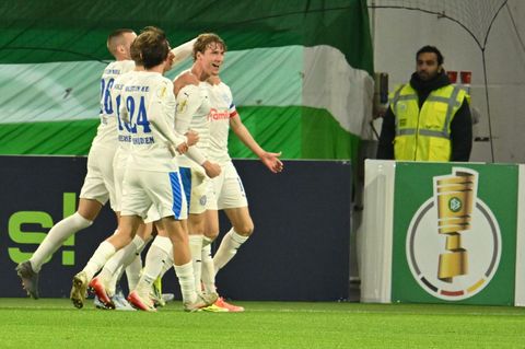 Sechs Spieler von Holstein Kiel jubeln im DFB-Pokal über das 1:0 gegen VFL Wolfsburg
