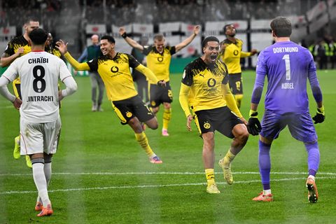 Die Dortmunder Spieler stürmen auf Elfmeter-Held Kobel zu. Foto: Arne Dedert/dpa