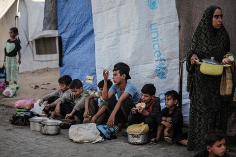 Kinder in Gaza Kinder sitzen am Straßenrand in Gaza, vor ihnen stehen Töpfe