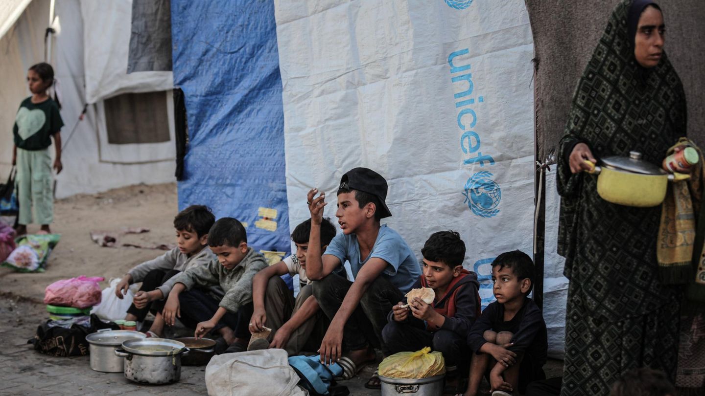 Kinder in Gaza Kinder sitzen am Straßenrand in Gaza, vor ihnen stehen Töpfe