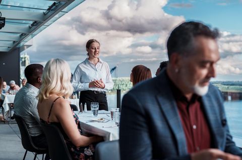 eine Kellnerin spricht mit den Gästen eine Kellnerin spricht mit den Gästen