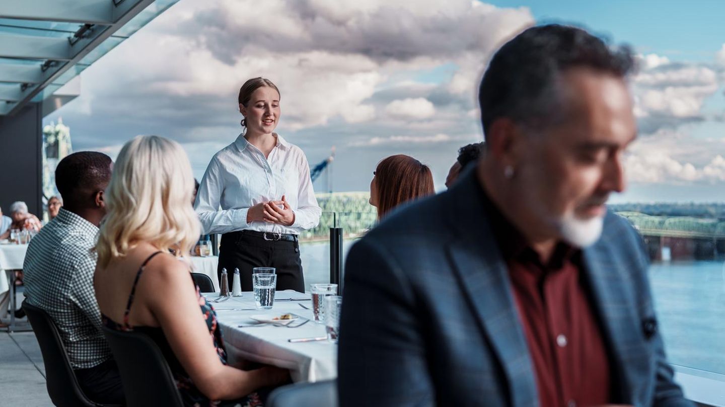 eine Kellnerin spricht mit den Gästen eine Kellnerin spricht mit den Gästen