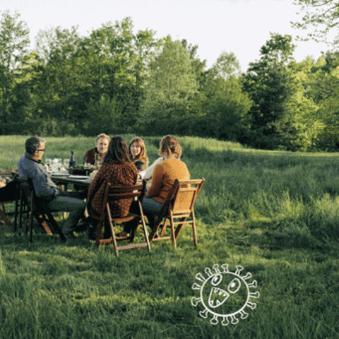Eien Gruppe Menschen sitzt auf einer Wiese in einem Kreis