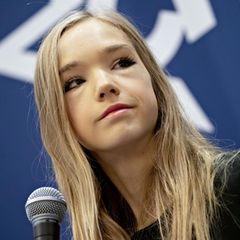 Naomi Seibt hält auf einer Bühne ein Mikro