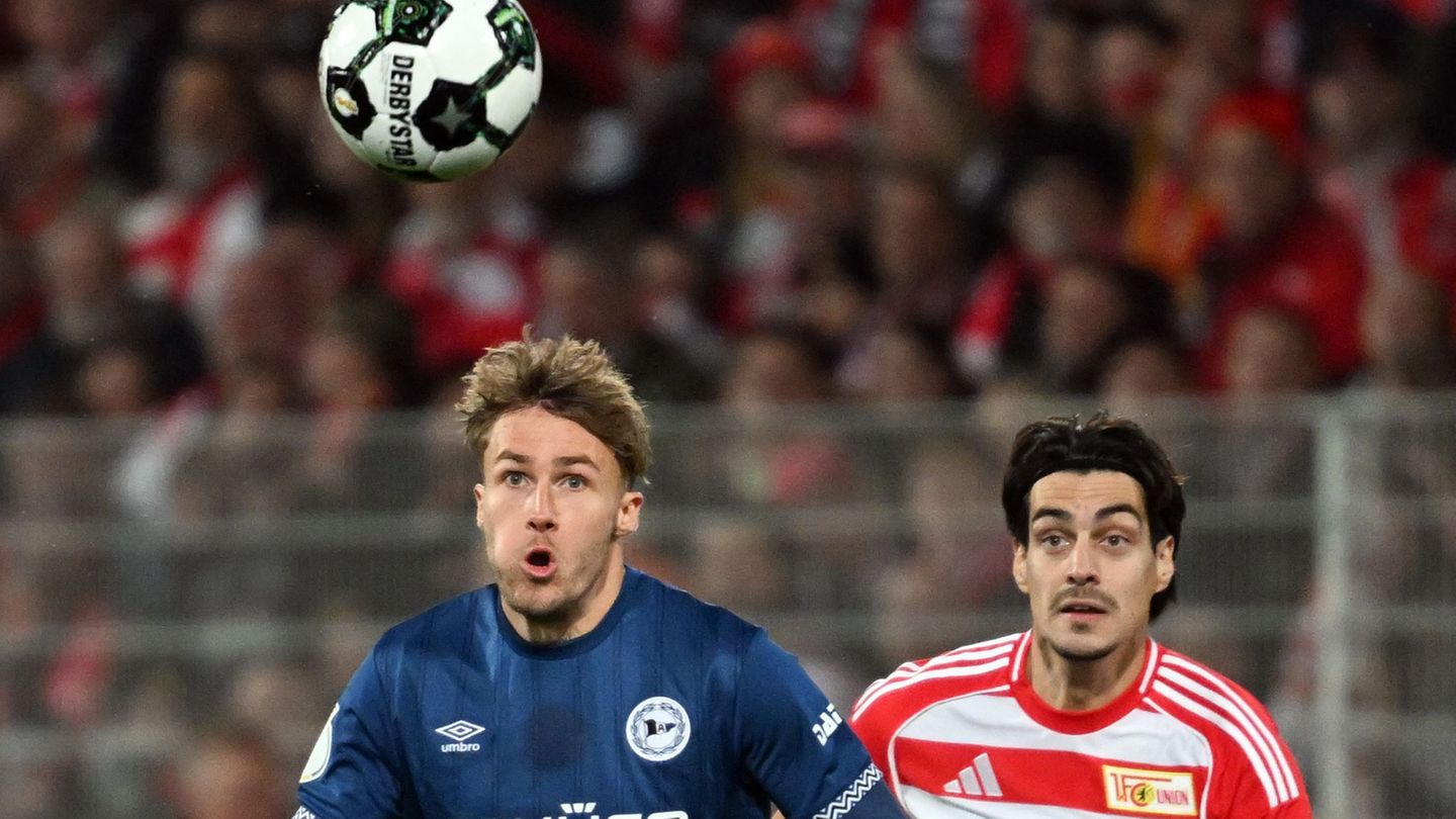 Bielefelds Kunze (l.) und Union Leite (r.) visieren den Ball an. Foto: Soeren Stache/dpa