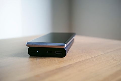 Person lädt Smartphone mit Powerbank auf