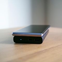 Powerbank im Angebot Person lädt Smartphone mit Powerbank auf