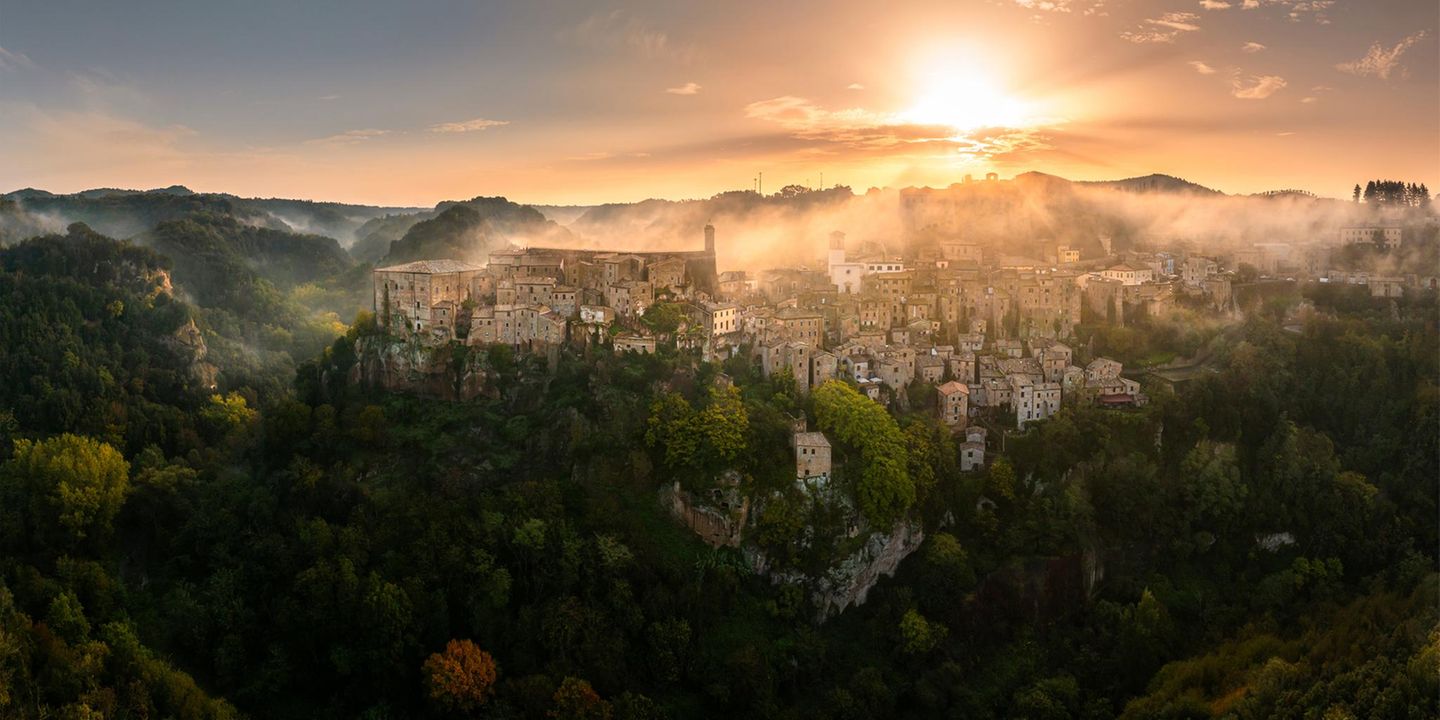 Stadt in den Wolken Als Stadt in den Wolken ist Sorano in der Toskana berühmt. Fotograf Quian Wang zeigt mit seinem Bild eine ganz neue Perspektive des beliebten Fotomotivs: Die grünen Hänge im Nebel lassen es wirken, als befände sich Sorano an einem fernen, fremden Ort. Sie erinnern sogar an die schwebenden Hügel im Film "Avatar", für die der Zhangjiajie-Nationalpark in der chinesischen Region Hunan Pate stand