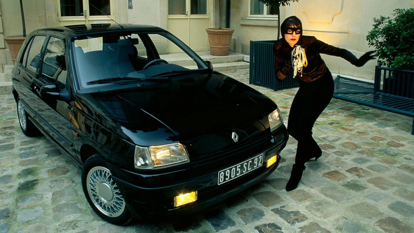 Renault Clio Baccara: Eine Frau mit Maske neben Renault Clio Baccara