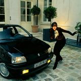 Eine Frau mit Maske neben Renault Clio Baccara