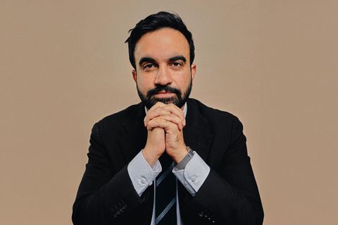 Zohran Momdani im Anzug vor einem neutralen Hintergrund