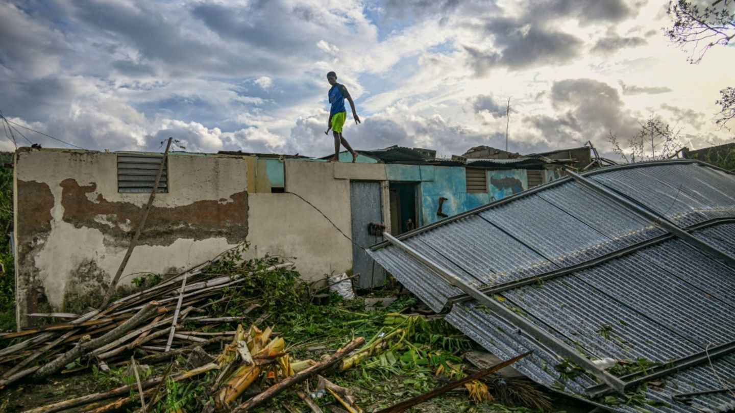 Mann steht in Kuba auf beschädigtem Haus Mann steht in Kuba auf beschädigtem Haus