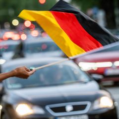 Ein Fußballfan schwenkt eine Deutschlandflagge