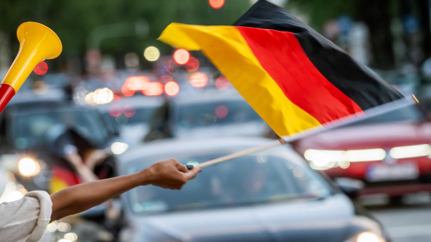 Ein Fußballfan schwenkt eine Deutschlandflagge