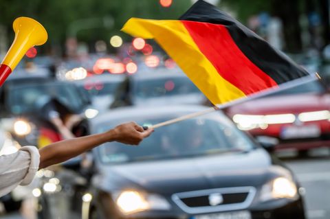 Ein Fußballfan schwenkt eine Deutschlandflagge