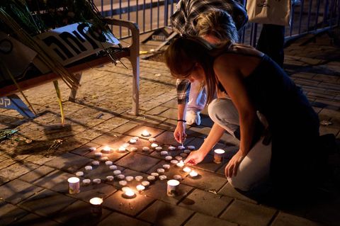 Frauen zünden vor dem gerichtsmedizinischen Institut Abu Kabir Kerzen an, in dem die Leichen der Geiseln identifiziert werden