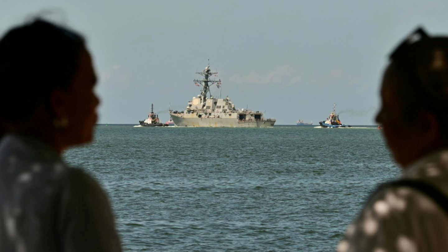 People watch the USS Gravely, a US Navy warship, departing Port of Spain on October 30, 2025 after arriving for joint exercises
