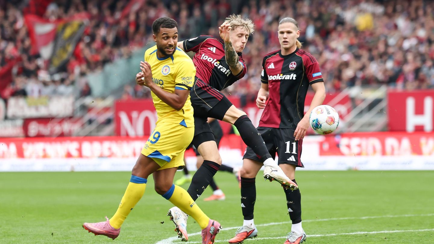 In Aktion: Tim Drexler vom 1. FC Nürnberg (M) und Leon Bell-Bell von Eintracht Braunschweig. Foto: Daniel Löb/dpa