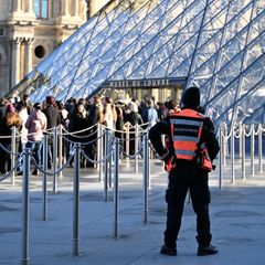 Menschen stehen Schlange, um das Louvre-Museum zu betreten