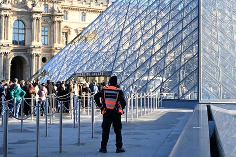 Menschen stehen Schlange, um das Louvre-Museum zu betreten