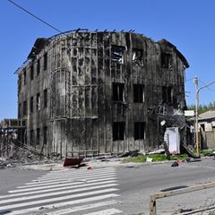 Ukraine: Anwohner gehen im Frühjahr 2024 an beschädigten Gebäuden im Zentrum von Pokrowsk vorbei