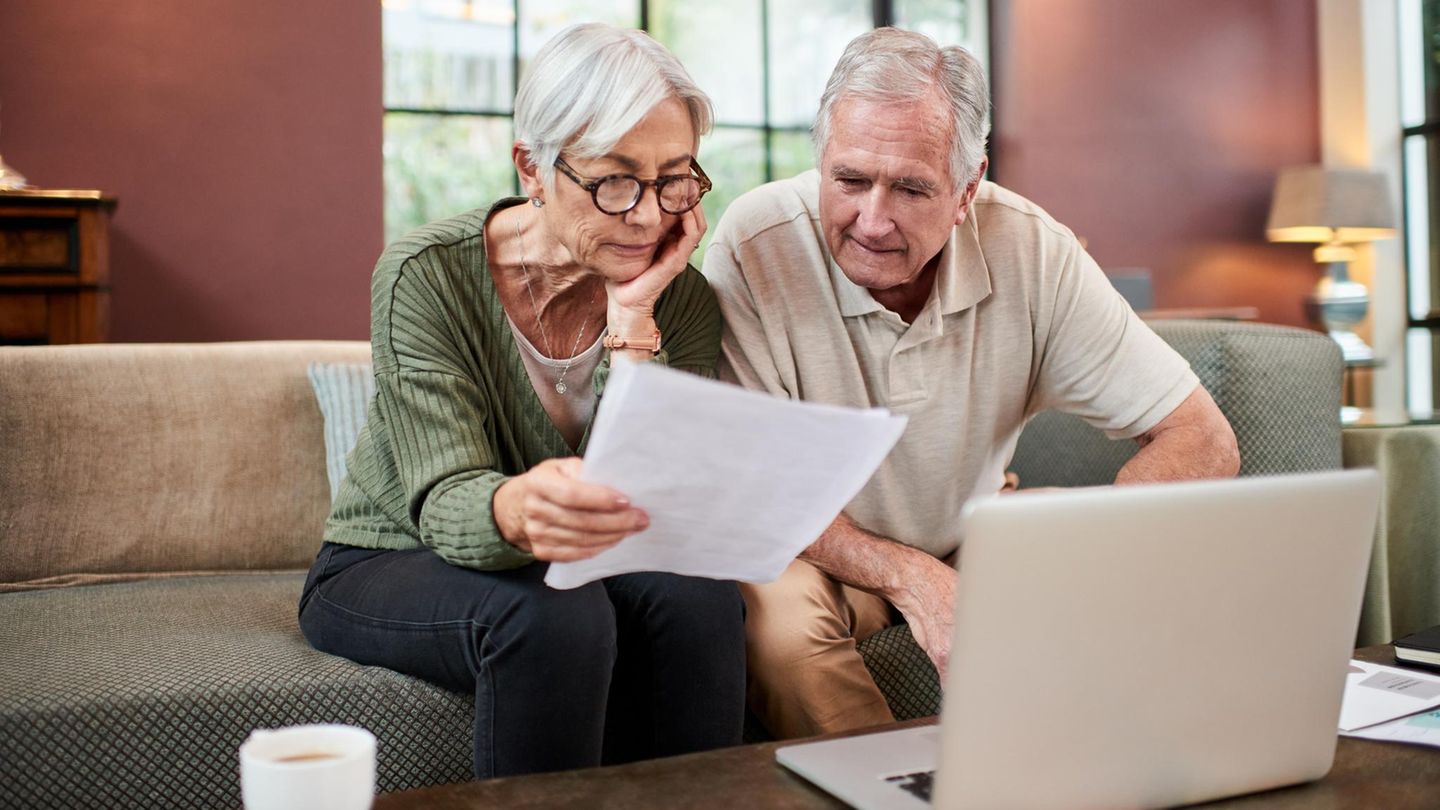 Ein älteres Paar sitzt vor einem Notebook und beschäftigt sich mit dem Erbe