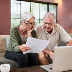 Ein älteres Paar sitzt vor einem Notebook und beschäftigt sich mit dem Erbe