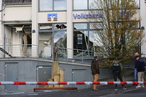 Ermittler der Polizei stehen in Paderborn vor einer beschädigten Bankfiliale. Foto: Christian Müller/dpa