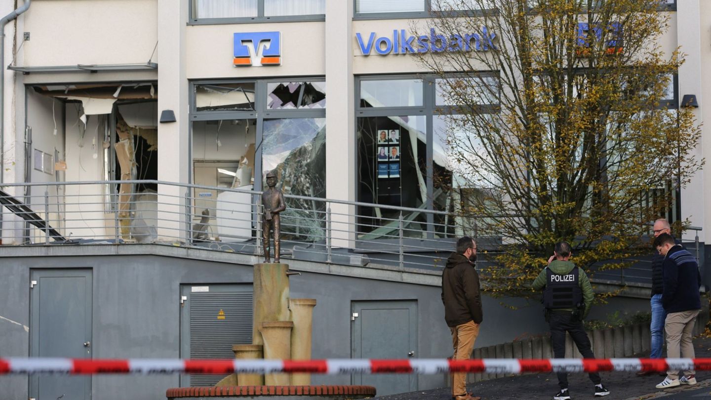 Ermittler der Polizei stehen in Paderborn vor einer beschädigten Bankfiliale. Foto: Christian Müller/dpa