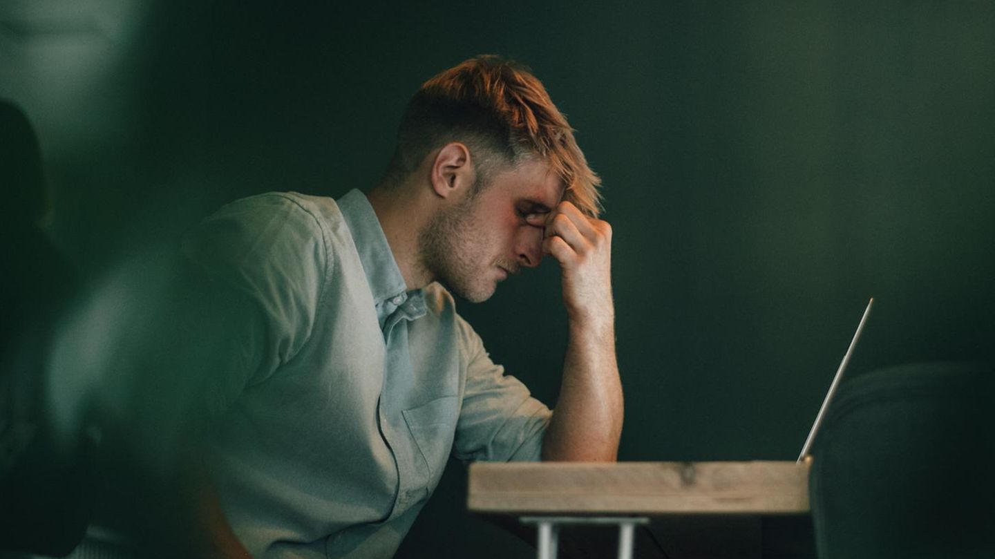 Selbstständiger sitzt vor Laptop in Krisensituation