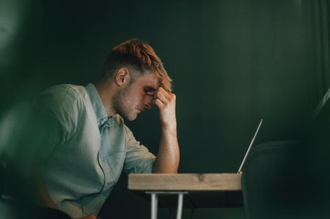 Selbstständiger sitzt vor Laptop in Krisensituation