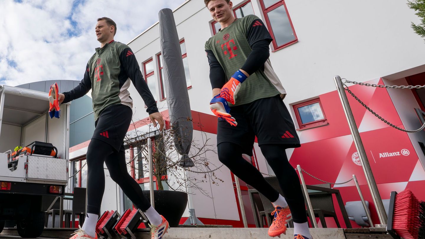 Torwart Manuel Neuer (l) und Ersatzkeeper Jonas Urbig auf dem Weg auf den Trainingsplatz. Foto: Peter Kneffel/dpa