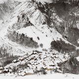 Ein Dorf vor einem schneebedeckten Berg in Frankreich