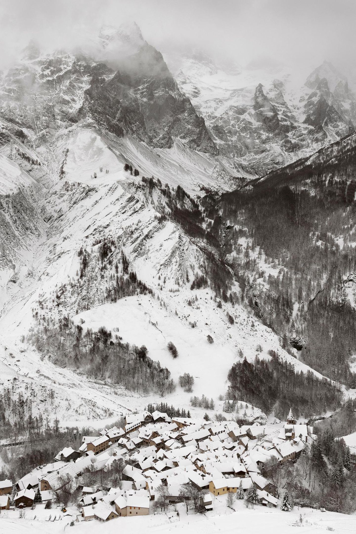 Ein Dorf vor einem schneebedeckten Berg in Frankreich