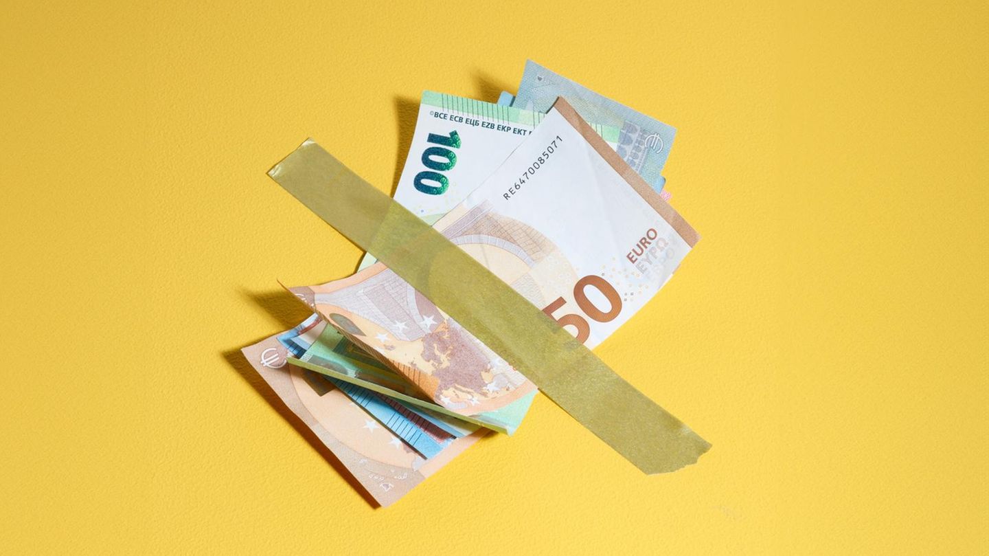 Geldscheine mit einem Klebestreifen auf gelbem Grund fixiert