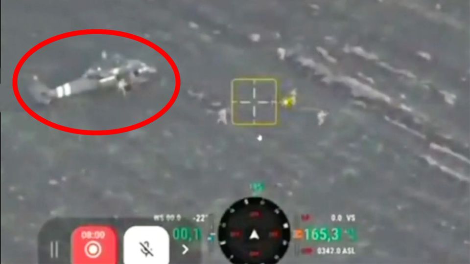 Aus dem gelandeten Hubschrauber stürmen mehrere ukrainische Soldaten über Brachland