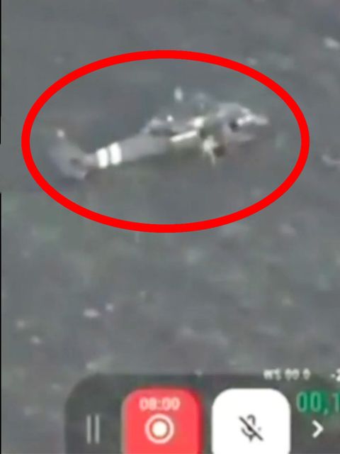 Aus dem gelandeten Hubschrauber stürmen mehrere ukrainische Soldaten über Brachland