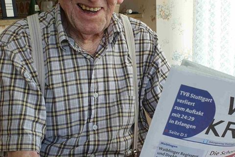 Karl Haidle sitzt an seinem 104. Geburtstag an einem Tisch und liest Zeitung. Foto: Sebastian Striebich/ZVW/dpa