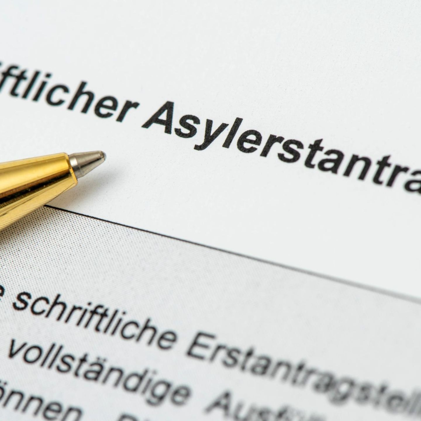 Ein Kugelschreiber liegt auf einem Asylerstantrag