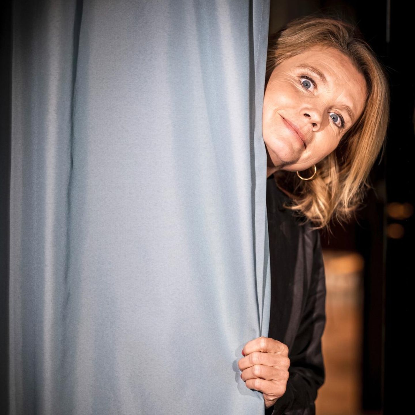Annette Frier hinter einem Bühnen Vorhang