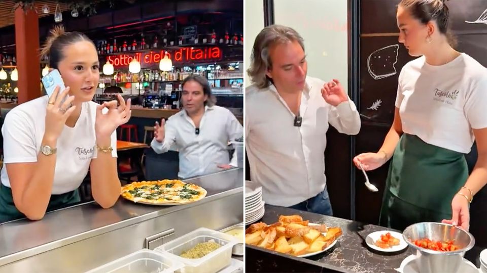 Die junge Angestellte lehnt telefonierend mit Handy am Tresen neben einer servierbereiten Pizza – von der Seite kommt ihr Chef.