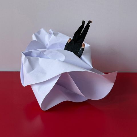 ein Papierknäeul, in den ein Pappfigur gesteckt ist